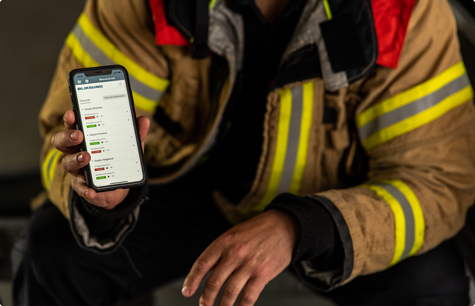 Firefighter viser frem det operative profesjonelle systemet GRID på en smarttelefon